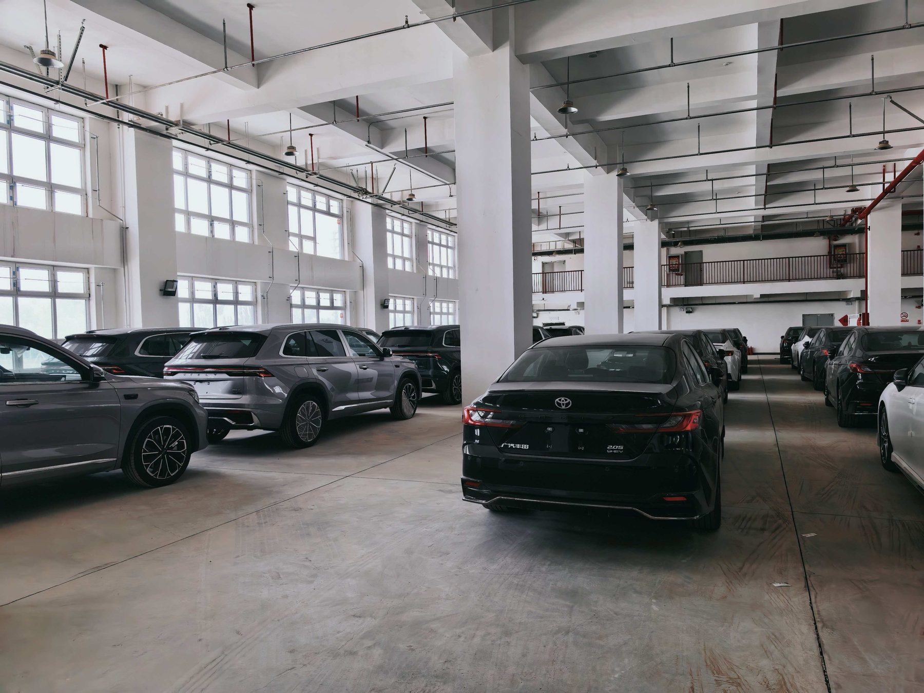 Vehicles stored inside an indoor warehouse before export delivery