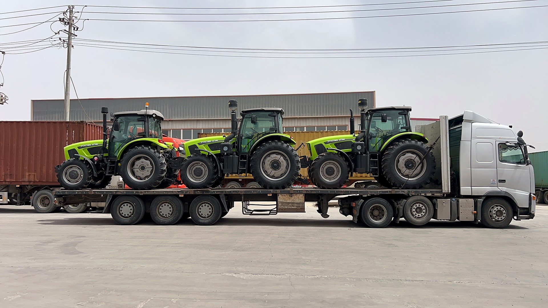Agricultural tractors loaded on a flatbed trailer